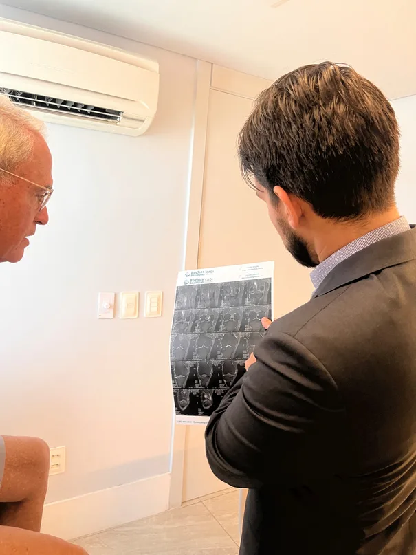 Dr. Leonardo analisando exames de imagem com paciente