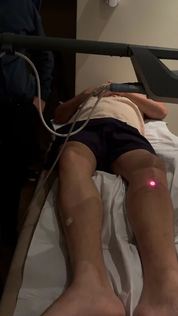 Paciente em sessão de laserterapia no joelho