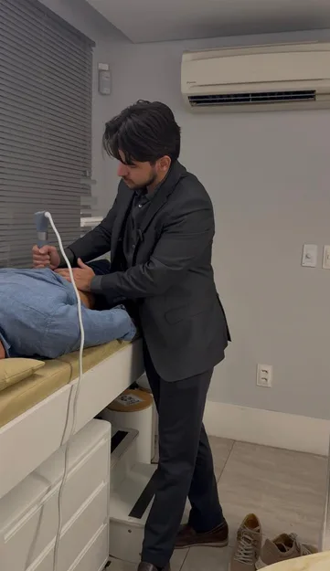 Dr. Leonardo avaliando paciente com ultrassom no consultório